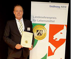 Geschäftsführer Karsten Schmidt und Jürgen Staiger nahmen die Auszeichnung aus der Hand von Landesminister Eckhard Uhlenberg entgegen. Die Verleihung fand im Rahmen einer feierlichen Siegerehrung in der Grugahalle Essen auf der Info-Tainmentbühne " NRW - vom Guten das Beste" - Messe für regionale Produkte Essen - statt. Der renommierte Ehrenpreis, der nur an Unternehmen vergeben wird, die sich durch einen langjährigen hohen Qualitäts-Standard ihrer Lebensmittel ausgezeichnet haben, ist einmal mehr der Beweis dafür, dass sich die Bäckerei Schmidt und ihre Mitarbeiter in "besonderem Maße um die Herstellung von qualitativ hochwertigen Lebensmitteln verdient gemacht" haben. Kein Wunder also, dass die prämierten Produkte der Bäckerei Karl Schmidt GmbH im Mühlenkreis und darüber hinaus in der Kundschaft bestens ankommen. Ein Handwerksbetrieb mit Vorzeige-Charakter – das ist die Bäckerei Karl Schmidt GmbH mit Sitz in Hedem. 1891 wurde der Grundstein für das Familienunternehmen gelegt, aus dem inzwischen ein Betrieb mit 45 Filialen geworden ist. Mit Millioneninvestitionen hat Geschäftsführer Karsten Schmidt seine Bäckerei für zukünftige Anforderungen fit gemacht – ohne dabei den handwerklichen Anspruch bei der Herstellung des Lebensmittels Brot in seinen vielen Facetten aus dem Auge zu verlieren.