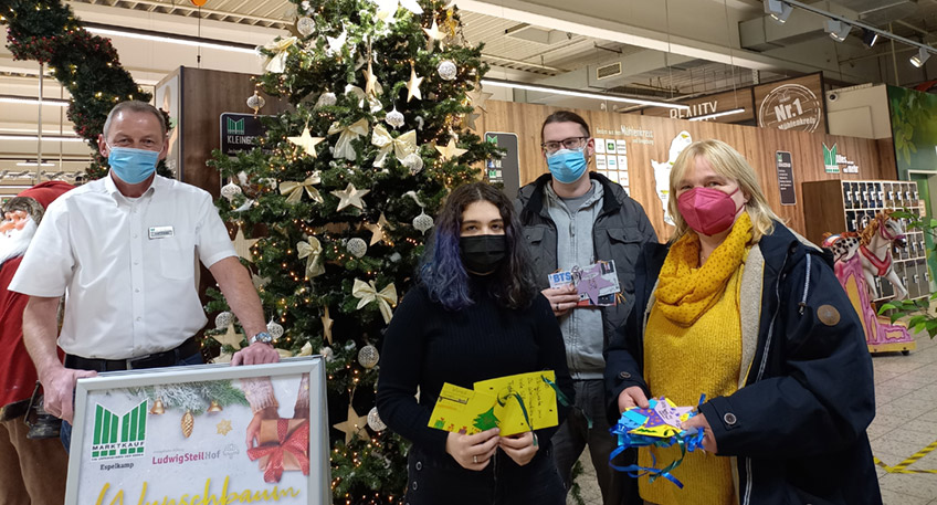 Auf ihre Weihnachtsgeschenke können sich schon jetzt die Kinder und Jugendlichen in den Wohngruppen des Ludwig-Steil-Hofes (LSH) freuen. Wieder konnten sie an der Weihnachts-Wunschbaumaktion des Marktkaufs teilnehmen. Marktleiter Karl Kordes hat zu diesem Zweck einen großen Weihnachtsbaum am Eingang des Verkaufsraums mit Kugeln, Schleifen und Lichterketten festlich schmücken lassen. Die Kinder aus den Wohngruppen der Jugendhilfe am LSH haben dazu die unterschiedlichsten Karten gebastelt, auf die sie ihre Weihnachts- und Geschenkwünsche geschrieben haben. Diese wurden zusätzlich an den Baum gehängt. Kunden des Marktkaufs sind dazu eingeladen, sich die Karten einmal anzuschauen und vielleicht einen der der darauf geäußerten Wünsche wahr werden zu lassen, indem sie ein Geschenk kaufen und an der Information abgeben. Über 40 liebevoll verpackte Weihnachtsgeschenke kamen auf diese Weise im vergangenen Jahr zusammen. Sie wurden - wie auch in diesem Jahr wieder - von LSH-Mitarbeitenden abgeholt und den Kinder zu den Festtagen übergeben. Die geäußerten Geschenkwünsche erstrecken sich von "ganz viel Süßigkeiten" über "1 Ball", verschiedene Spiele, Bücher unterschiedlichen Inhalts, Kosmetika oder LEGO-City-Bausteine bis hin zum ganz pragmatischen Einkaufsgutschein.