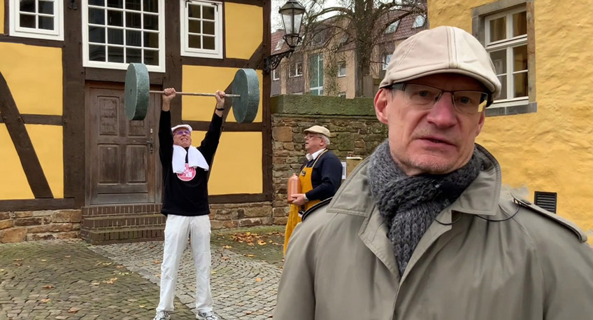 Bei der Erlebnisf&uuml;hrung &bdquo;L&uuml;bbecke zur Kaiserzeit&ldquo; mit Reporter Fritz (alias Uwe Feldmann, vorn) treffen die Teilnehmer auf ganz unterschiedliche L&uuml;bbecker B&uuml;rger (hier im Hintergrund ein Turner und ein Schnapsbrenner dargestellt von Horst Sch&uuml;rmann und Bernhard Kostka), die aus ihrem Alltag berichten.