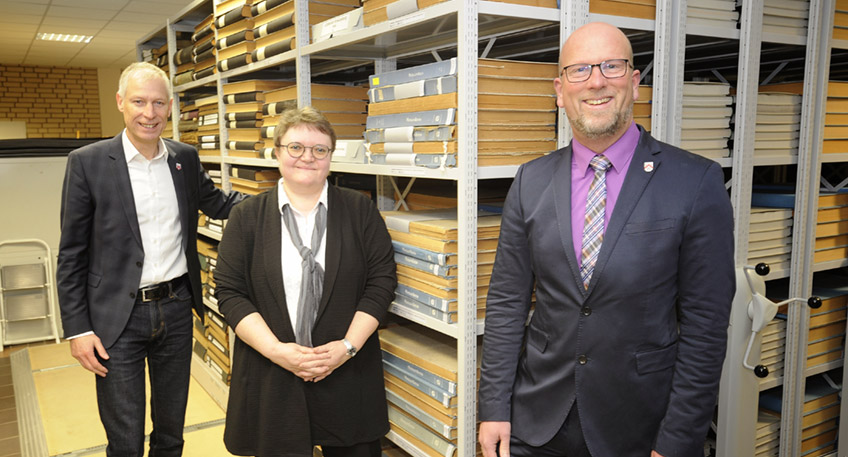 Die Leiterin des Lübbecker Stadtarchivs, Christel Droste, eingerahmt von den Bürgermeistern Marko Steiner (Pr. Oldendorf, re.) und Frank Haberbosch in einem der Magazinräume, die künftig neben den eigenen und denen der Gemeinde Stemwede auch die Bestände der Stadt Pr. Oldendorf beherbergen werden.