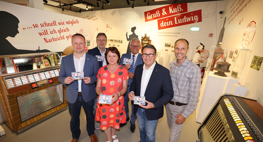 Automatengeschichte zum Anfassen: Annika Maucher an einem Münzautomaten, der Schokolade, Bonbons und Ansichtskarten zur Verfügung stellt.